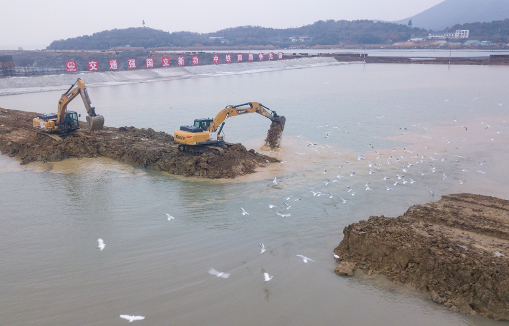 2019年12月23日，鳥群從陸島轉(zhuǎn)換圍堰回水施工現(xiàn)場飛過。
